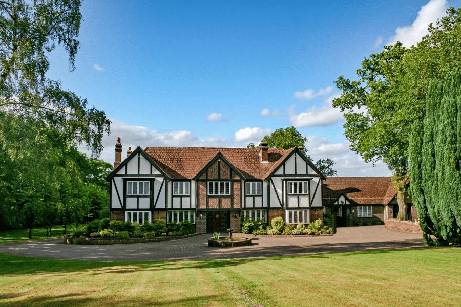 expansive tudor style home with large front lawn